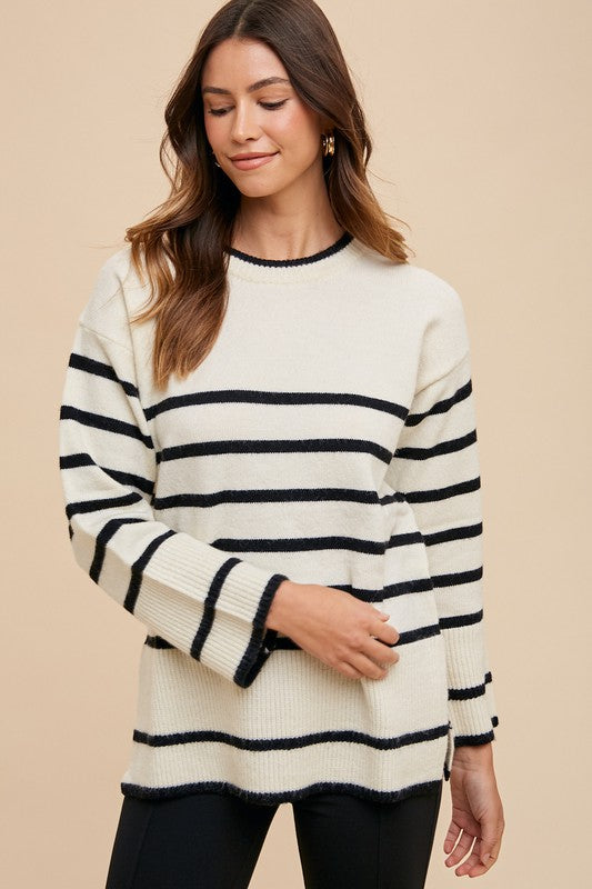 Annie Wear Side Slit Striped Round Neck Sweater featuring black and white stripes, side slits, and a cozy fit.