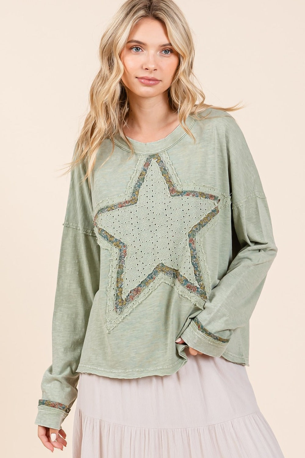 A Cute woman wearing a green long sleeve t-shirt with a star patch