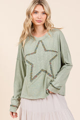 A Cute woman wearing a green long sleeve t-shirt with a star patch
