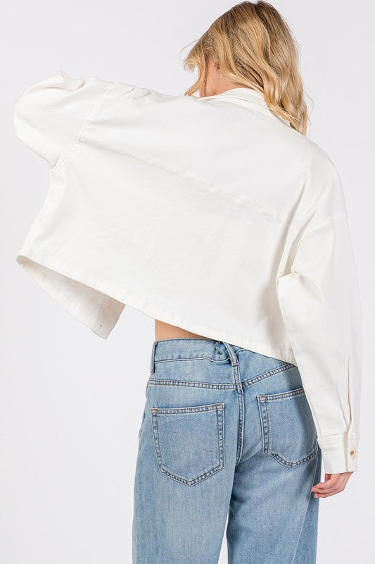 Back view of a cropped white denim jacket paired with high-waisted jeans, showcasing its stylish silhouette.