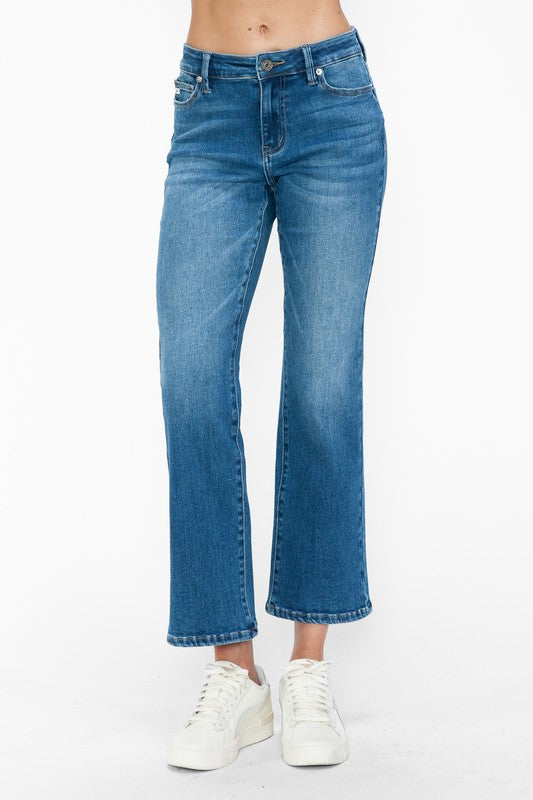 Stylish mid-rise ankle jeans in light blue denim, featuring a relaxed fit and paired with casual white sneakers.