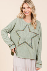 A Smiling woman wearing a green long sleeve t-shirt with a star patch
