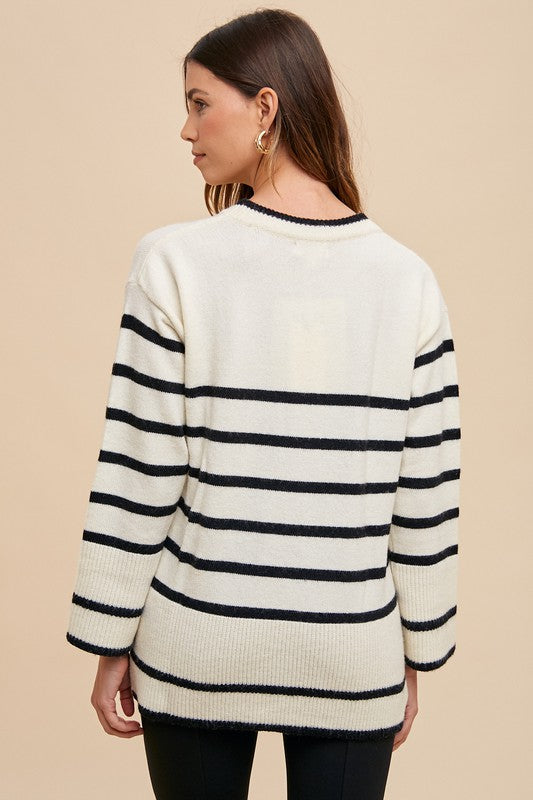 Back view of the Annie Wear striped round neck sweater, showcasing its chic side slits and modern design.