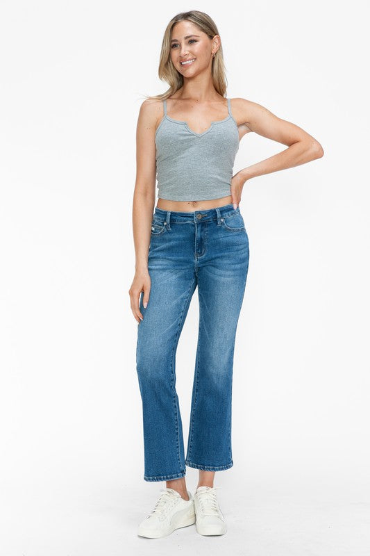 Model wearing bytos Cat's Whiskers Mid Rise Ankle Jeans paired with a gray crop top and white sneakers.