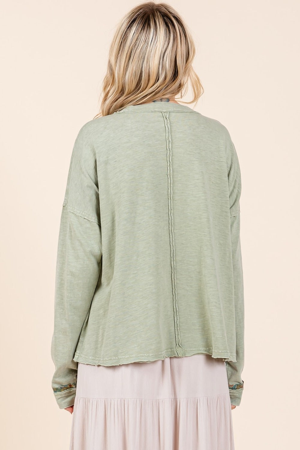 A woman wearing a green long sleeve t-shirt