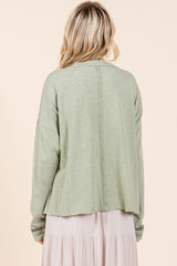 A woman wearing a green long sleeve t-shirt