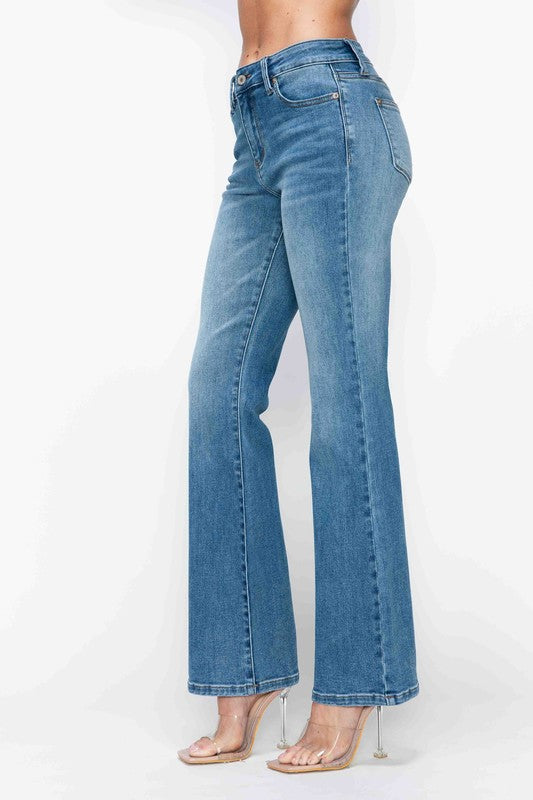 Mid-rise bootcut jeans with whimsical cat's whiskers detailing, modeled on a woman in stylish transparent heels.