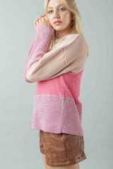 Side shot of the model wearing the color-blocked sweater to illustrate its profile and fit over brown leather-look shorts. The image clearly shows the contrasting knit textures.