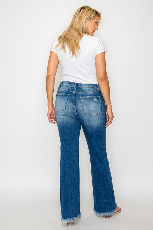 Woman wearing bytos full size raw hem distressed bootcut jeans, showing back view with light blue wash and trendy flare.